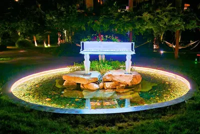 a white piano sitting in a pond at night at Attractive Family Apartment in Sunny Beach Cascadas Family Resort in Sunny Beach