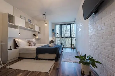 a bedroom with a bed and a brick wall at Студио в близост до Община Варна in Varna City
