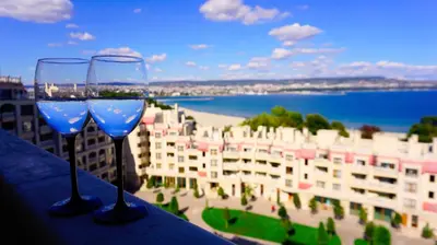 two wine glasses sitting on a balcony with a view of the beach at Апартаменти Варна Саут на плажа 2 - Varna South Apartments on the beach 2 in Varna City