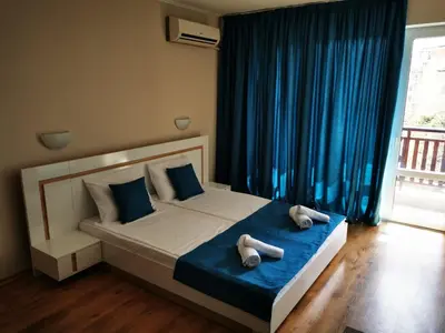 a bedroom with a bed with two towels on it at Студио Sun day в Royal palm, Свети Влас in Sveti Vlas