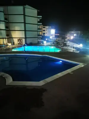 an empty swimming pool at night with lights at Студио Sun day в Royal palm, Свети Влас in Sveti Vlas