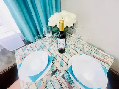 a table with a bottle of wine and flowers on it at By The Sea - central with free parking in Varna City
