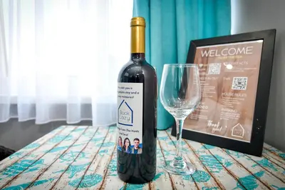 a bottle of wine sitting next to a wine glass at By The Sea - central with free parking in Varna City