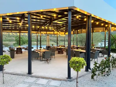 an outdoor patio with tables and chairs and lights at Drive Point (Adventure Lake Resort) in Asparukhovo