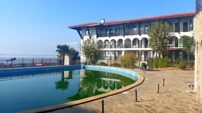 a building with a pool of water in front of a building at Monastery II Garden stay like home in Sveti Vlas