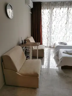 a room with a chair and a bed and a window at Admiral Plaza Sunrise Apartments C13 in Sunny Beach