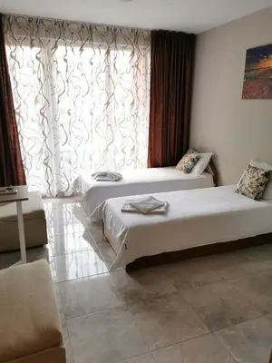 two beds in a room with a large window at Admiral Plaza Sunrise Apartments C13 in Sunny Beach