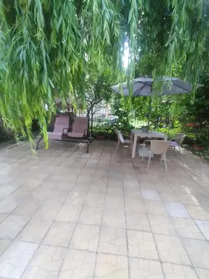 a patio with tables and chairs and an umbrella at Ваканционно студио Аквария in Sunny Beach