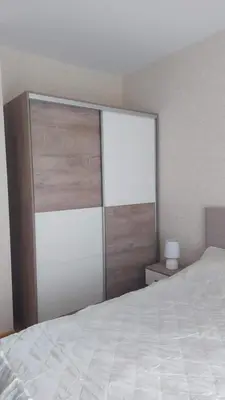 a bedroom with a white bed and a sliding door at Aphrodite Park in Sunny Beach
