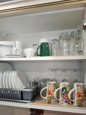 a shelf filled with dishes and glass jars at Afrodita Palas , studio appartment 4 floor, pool view in Sunny Beach