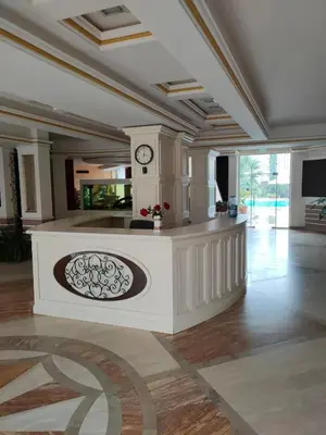 a large living room with a clock on the wall at Afrodita Palas , studio appartment 4 floor, pool view in Sunny Beach