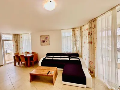 a bedroom with a bed and a table in it at Charming 2-bed flat with pool view in Sunny Beach, Bulgaria in Sunny Beach