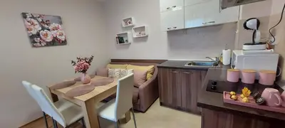 a kitchen and a dining room with a table and a couch at Студио Ервина in Ravda