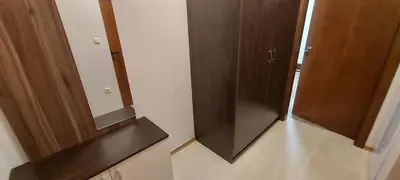 a bathroom with two wooden cabinets and a mirror at Студио Ервина in Ravda