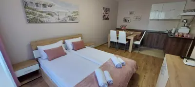 a small bedroom with a large bed and a kitchen at Студио Ервина in Ravda