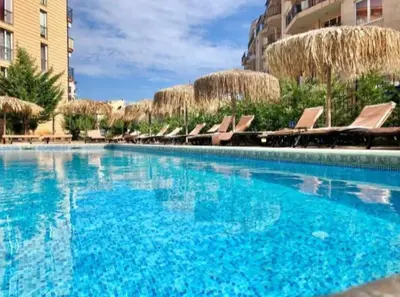 a large swimming pool with chairs and blue water at Sunny beach apartaments in Sunny Beach