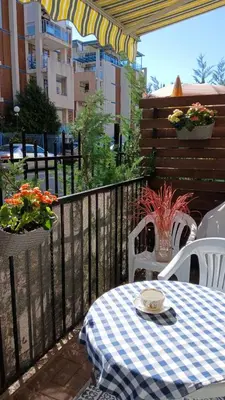 a table and chairs on a balcony with a table and flowers at Sunny beach apartaments in Sunny Beach