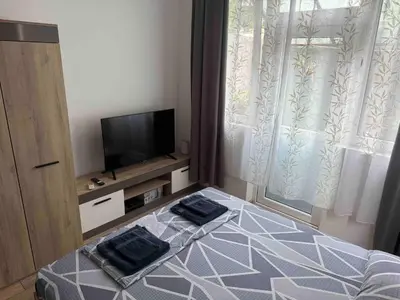 a bedroom with a bed and a tv and a window at Studio 