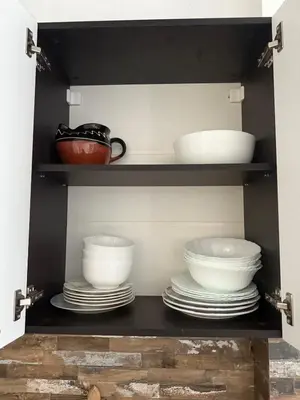 a cabinet filled with white bowls and plates at Studio 