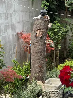 a statue of a man sitting on top of a tree stump at Studio 