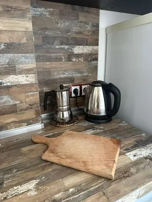 a coffee pot and a tea kettle on a wooden cutting board at Studio 