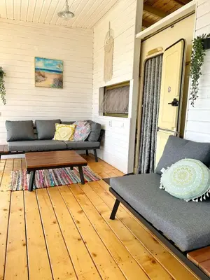 a porch with a couch and a coffee table at каравани Дрийм Арапя in Tsarevo