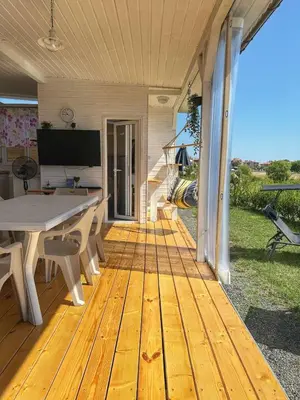 a wooden deck with a table and chairs on a house at каравани Дрийм Арапя in Tsarevo