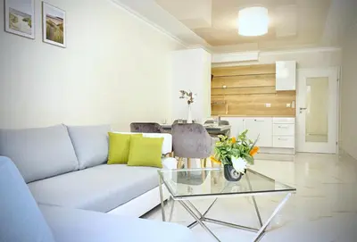 a living room with a couch and a glass table at Sea View Apartment with Free Parking in Pomorie