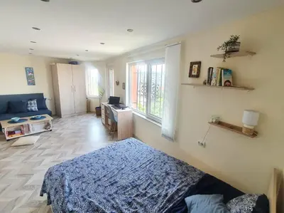 a bedroom with a blue bed and a living room at Sunset Dreams apartment in Burgas City