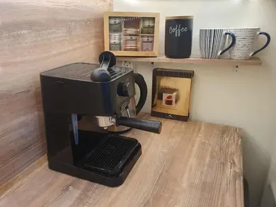 a coffee machine sitting on a wooden table with a cup at Sunset Dreams apartment in Burgas City