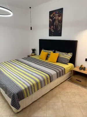 a bedroom with a large bed with yellow pillows at Eve Santa Marina Apartments II - sea, pools, relax in Sozopol