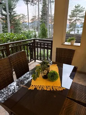 a table with a yellow napkin and a vase on it at Eve Santa Marina Apartments II - sea, pools, relax in Sozopol