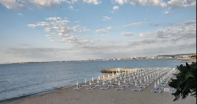 a row of chairs on a beach next to the water at Studio Sveti Vlas 