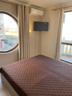 a bedroom with a bed and a flat screen tv at Частен апартамент Стамополу - Private Two-Bedroom Apartment Stamopolu in Primorsko
