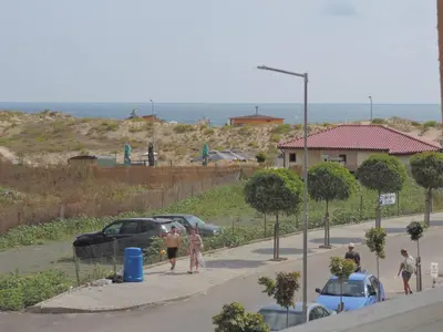 a group of people walking down a street with cars at Частен апартамент Стамополу - Private Two-Bedroom Apartment Stamopolu in Primorsko