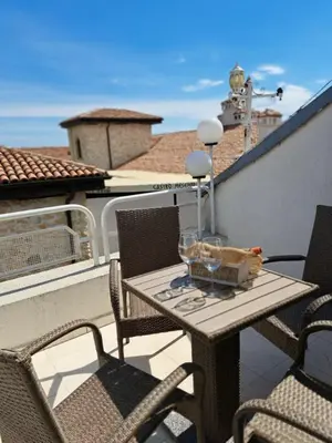 a table and chairs on a balcony with a view of the ocean at The White House in Nesebar