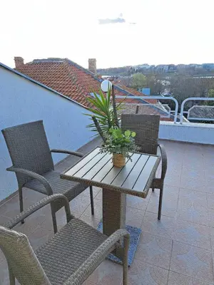 a wooden table and chairs on a balcony at The White House in Nesebar