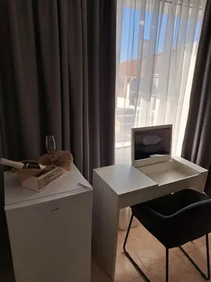 a desk with a computer and a chair next to a window at The White House in Nesebar