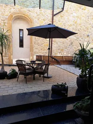 a table and chairs with an umbrella in a courtyard at The White House in Nesebar