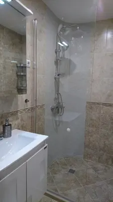a bathroom with a shower and a white sink at Сити бийч вю in Tsarevo