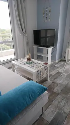 a living room with a tv and a couch and a table at Сити бийч вю in Tsarevo