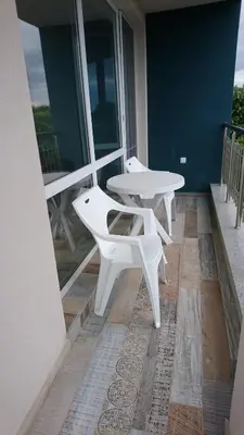 two white tables and chairs on a balcony at Сити бийч вю in Tsarevo