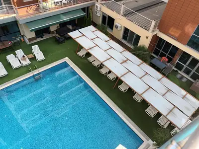 an overhead view of a pool with chairs and a hotel at Apartment Ground Floor in Pomorie