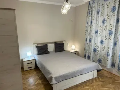 a bedroom with a bed with two night stands and two lamps at Niya Apartment Bourgas in Burgas City