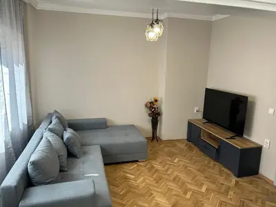 a living room with a couch and a flat screen tv at Niya Apartment Bourgas in Burgas City