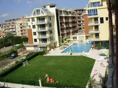 a large yard with a pool in front of a building at Apartament Milenium in Pomorie