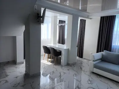 a living room with a table and chairs and a couch at Apartament Milenium in Pomorie