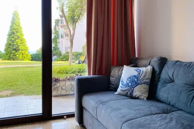 a couch sitting in front of a sliding glass door at APARTELLO⊛com DIAMOND - private apartments near Marina Dinevi in Sveti Vlas in Sveti Vlas