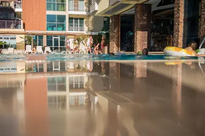 a pool with people swimming in the water at Апартамент в Комплекс Милениум in Pomorie