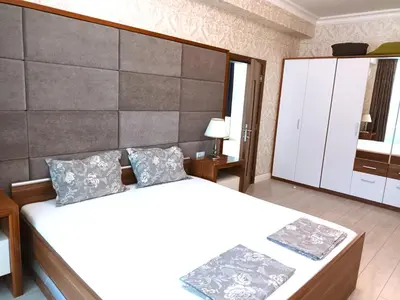 a bedroom with two beds and a large wall at Апартамент в Комплекс Милениум in Pomorie